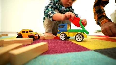 Closeup of little boy hands playing with car and wooden constructor building hou 스톡 동영상 119902969