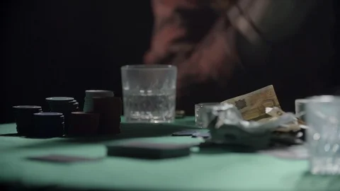 Closeup lockdown shot of young friends playing poker at table while smoking - Stock Footage 129430015