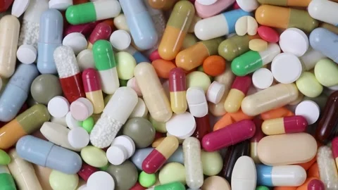 Closeup loop of pile of pills and capsules rotating Video stock 161029441