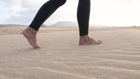 Closeup low angle gimbal shot of female feet walking in beautiful sand in desert Stock Footage 126100988