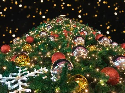 Closeup low angle or bottom view of giant christmas tree with bokeh in the ni Stock Photos