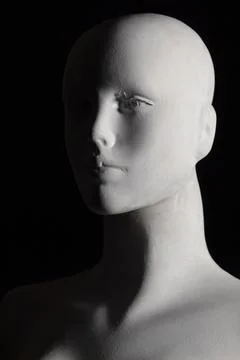 Closeup in low angle shot to a white female manikin with black background 스톡 사진
