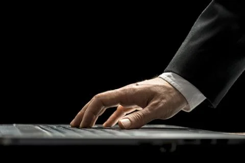 Closeup low angle view of the hand of a businessman in a suit using a lapto.. Stock Photos