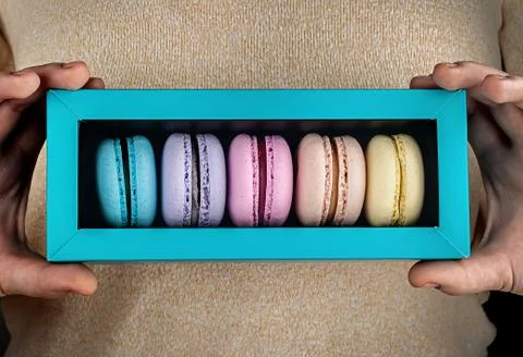 Closeup macaroons in gift box in hands Stock Photos