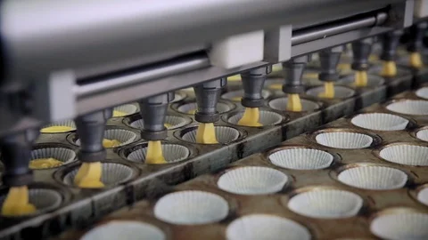 Closeup of Machine pouring paste in moulds on a food factory’s production Stock Footage 128821394