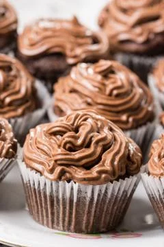 Closeup macro of chocolate cup cakes with ganache chocolate cream on the top Stock Photos
