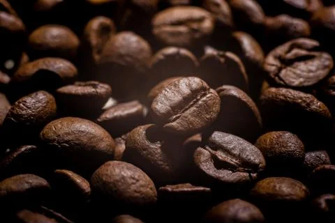 Closeup macro a group roasted brown or black coffee beans background Stock Photos