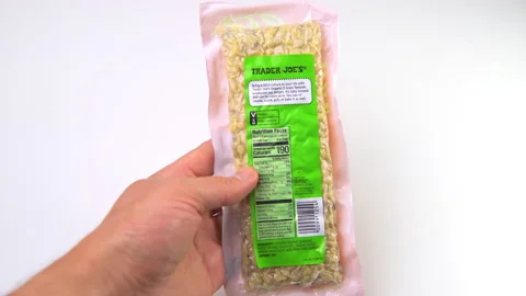 Closeup macro of hand holding Trader Joe's organic soybeans tempeh package Stock-Footage 178994296