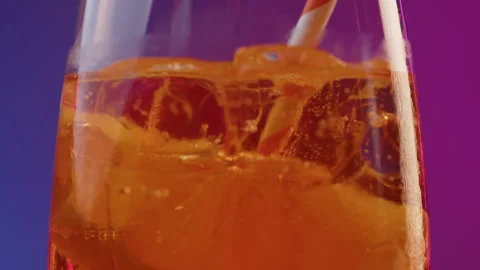Closeup macro pano shot of cocktail glass with orange aperol spritz with ice and Video stock 246738531