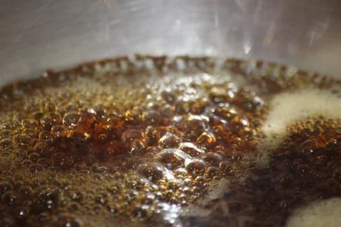 Closeup macro photograph with selective focus of boiling brown water Stock Photos
