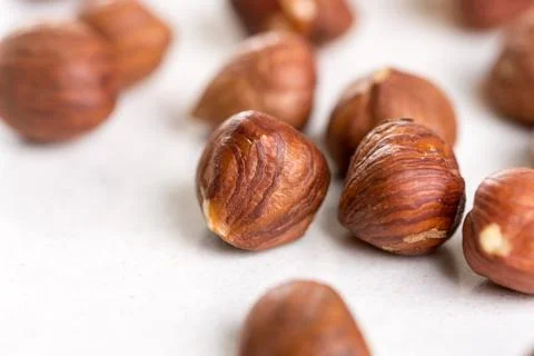 Closeup macro of raw hazelnuts on the white marble background Stock Photos
