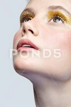 Closeup macro shot of human female eye with yellow smoky eyes beauty makeup. Stock Photos