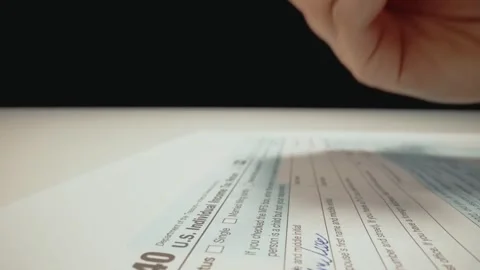 Closeup macro shot movement shot of corporate accountant lling 1040 tax form. Stock Footage 243363408