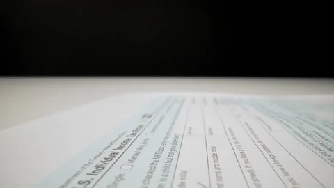 Closeup macro shot movement shot of corporate accountant lling 1040 tax form. Stock Footage 247326539