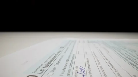Closeup macro shot movement shot of corporate accountant lling 1040 tax form. Stock Footage 251109840