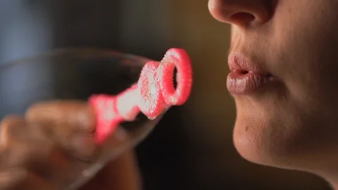 Closeup macro slow motion lips blowing bubbles from pink bubble wand Stock Footage 111620585