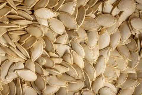 Closeup macro texture of raw edible pumpkin seeds background Stock Photos