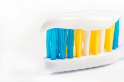 Closeup macro toothpaste on toothbrush isolated over white background with co Stock Photos