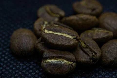 Closeup macro view of coffee beans laid on a black background after roasting  Stock-Fotos