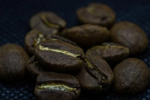 Closeup macro view of coffee beans laid on a black background after roasting  Stock-Fotos