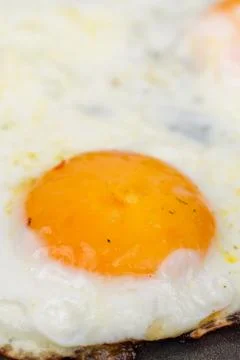 Closeup macro view of fried eggs in teflon frying pan Foto stock
