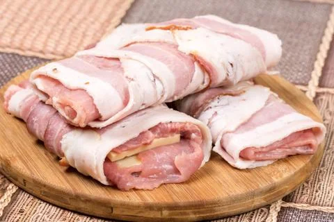 Closeup macro view stuffed meat with yellow cheese in bacon Stock Photos