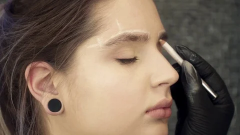 Closeup of makeup artist correcting the shape of the eyebrows Stock Footage 73673271