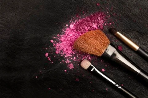 Closeup of makeup brushes with eye shadow on black with copy space 스톡 사진