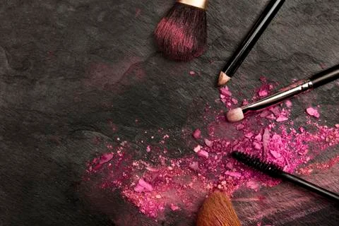 Closeup of makeup brushes with eye shadow on black with copy space Foto stock