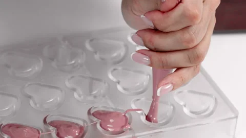 Closeup making exclusive ruby chocolate heart shaped candies, slow motion Video stock 140370066