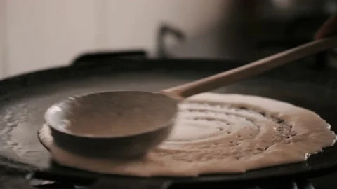 Closeup of making steaming hot 'Dosa' on a cast iron pan Stock Footage 130836465