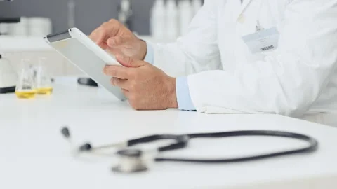 Closeup of male doctors hands using digital tablet. Medical expert scrolling and Stock Footage 254765282