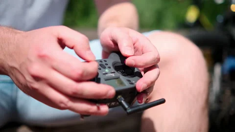 Closeup, male hands remote control sticks of control of FPV racing drone Stock Footage 170671081