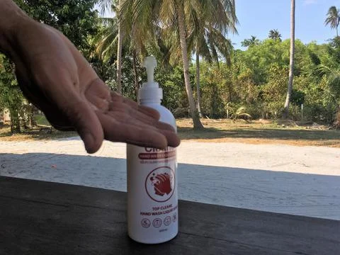 CLOSEUP, MALE HANDS USING SANITIZING GEL, OUTDOORS, NATURE 库存照片