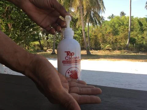 CLOSEUP, MALE HANDS USING SANITIZING GEL, OUTDOORS, NATURE 库存照片