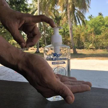 CLOSEUP, MALE HANDS USING SANITIZING GEL, OUTDOORS, NATURE Stock Photos