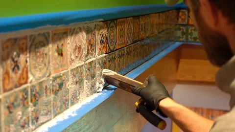 Closeup of male worker applying grout to a row of tiles. Stock Footage 101434717