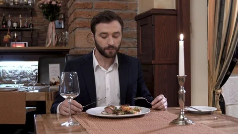 Closeup of man with a beard sitting at the table in restaurant. Eating meat 스톡 동영상 89042920