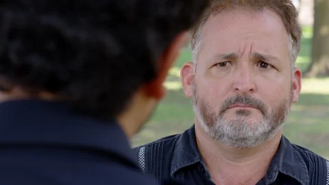 Closeup - A man is being berated by another man while outside at a park - shot Stock Footage 124719029