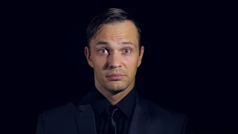 Closeup of a man in black clothes on black background. 4k. Slow motion. man Stock Footage 80005732