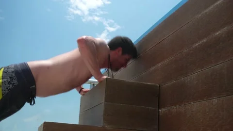 Closeup of a man doing push-up exercises on the ladder of a swimming pool in a Video stock 172271161