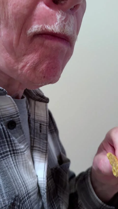 Closeup of a Man Eating a Corn Chip - Vertical Stock Footage 293847404