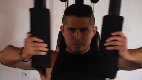 Closeup of a man exercising on a pec deck machine Stock Footage 146504575