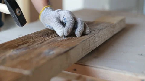 Closeup of a man hammering a used nail into old boards Stock Footage 67896014