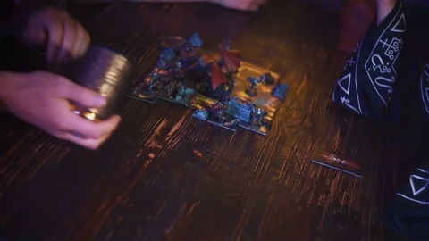 Closeup of man hand in armor rolling dice with shaker cup for fantasy board game Stock Footage 79441748