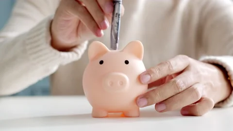 Closeup man hand put banknote money to piggy bank, saving and deposit money Stock Footage 146980113