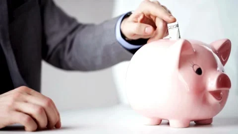 Closeup man hand put coin money to piggy bank, savings and deposit money co.. Stock Footage 265935035