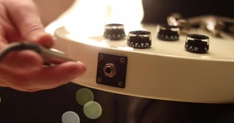 Closeup man hand sticking plug to guitar in concert hall. Unrecognizable pers Stock Footage 305770431