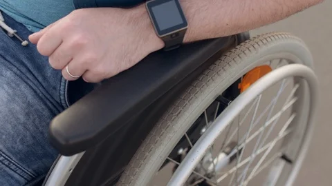 Closeup of man hand turning wheels on his wheelchair. Stock Footage 110224269