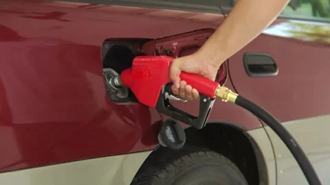 Closeup of man hand using petrol pump to filling car up with fuel standing near Stock Footage 336569546
